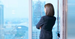 A business woman looking out of a window.